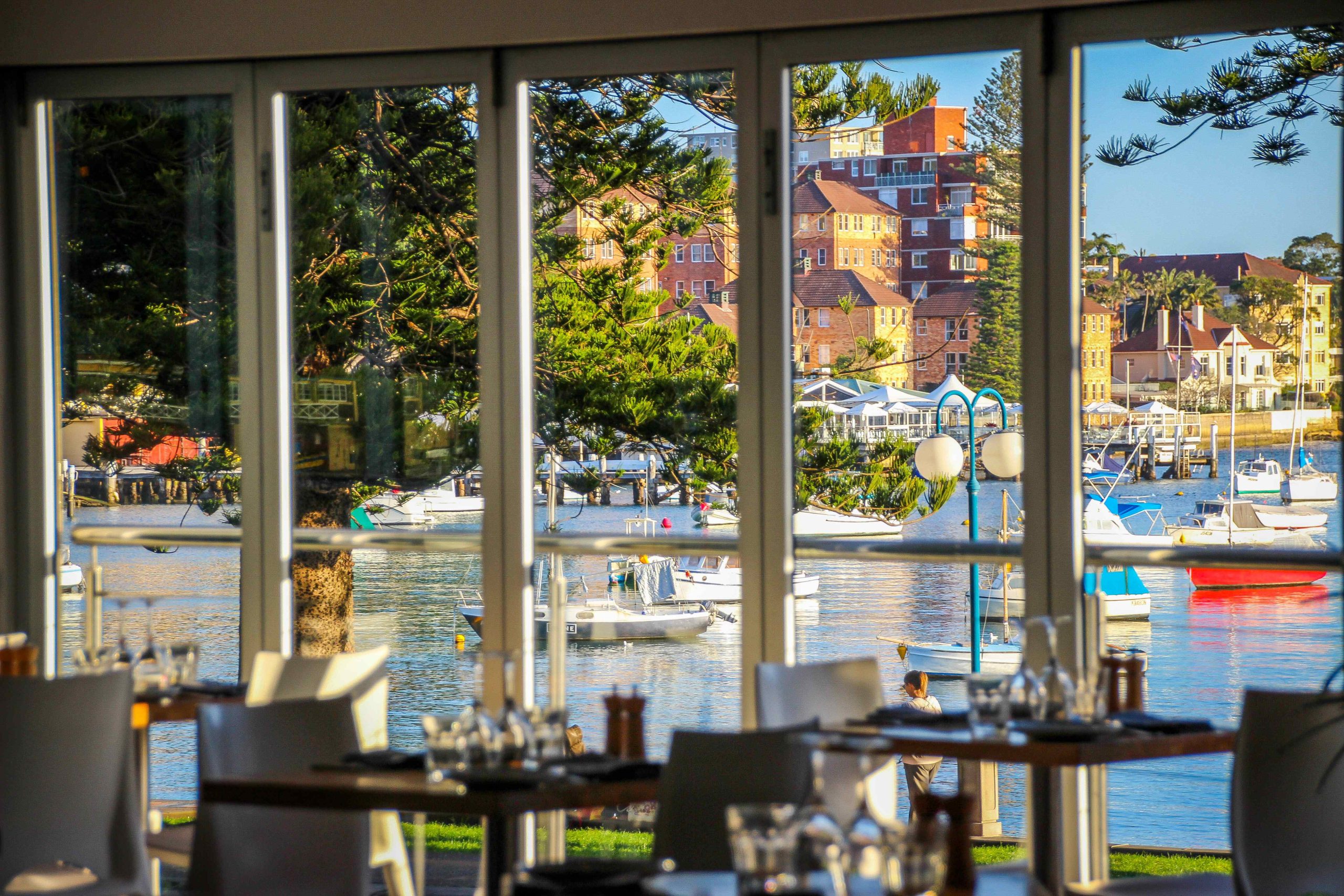 The view over the city and a colourful coastal town from the the glass-window interiors of a restaurant in Sydney