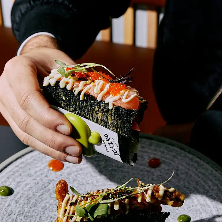 A diner holds a sushi taco served at Ichrio Izakaya Bar, one of the best Japanese restaurants in Melbourne.