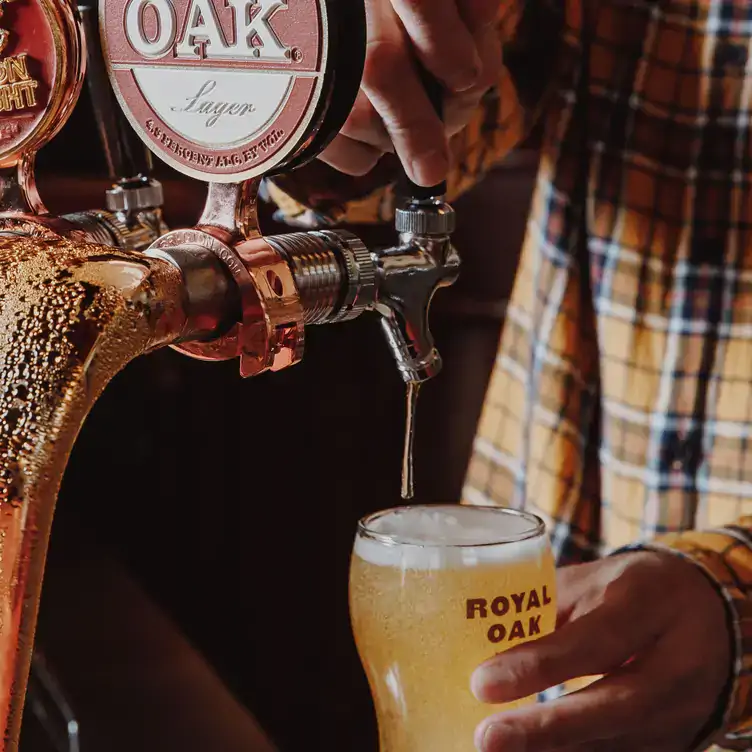 A bartender serves a pint of beer at the Royal Oak Hotel in Melbourne