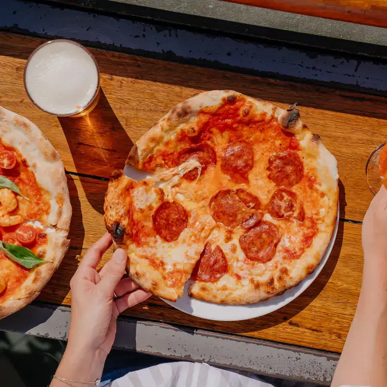 A diner grabs a slice of pizza at Newtown Hotel, one of the best pubs in Sydney