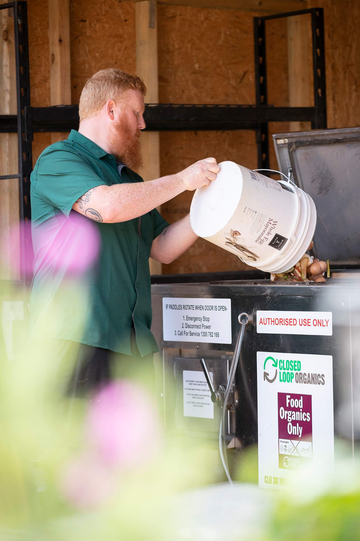 A man pouring food scraps into an organic composting bin at Canberra cafe Two Before Ten.