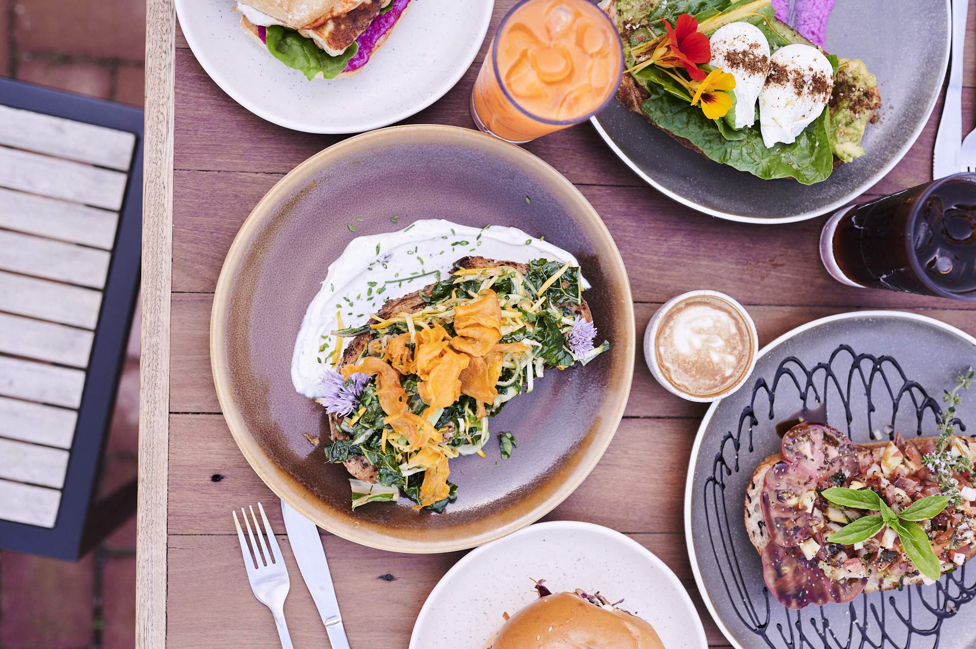 A brown table filled with a spread of colourful brunch dishes and drinks.