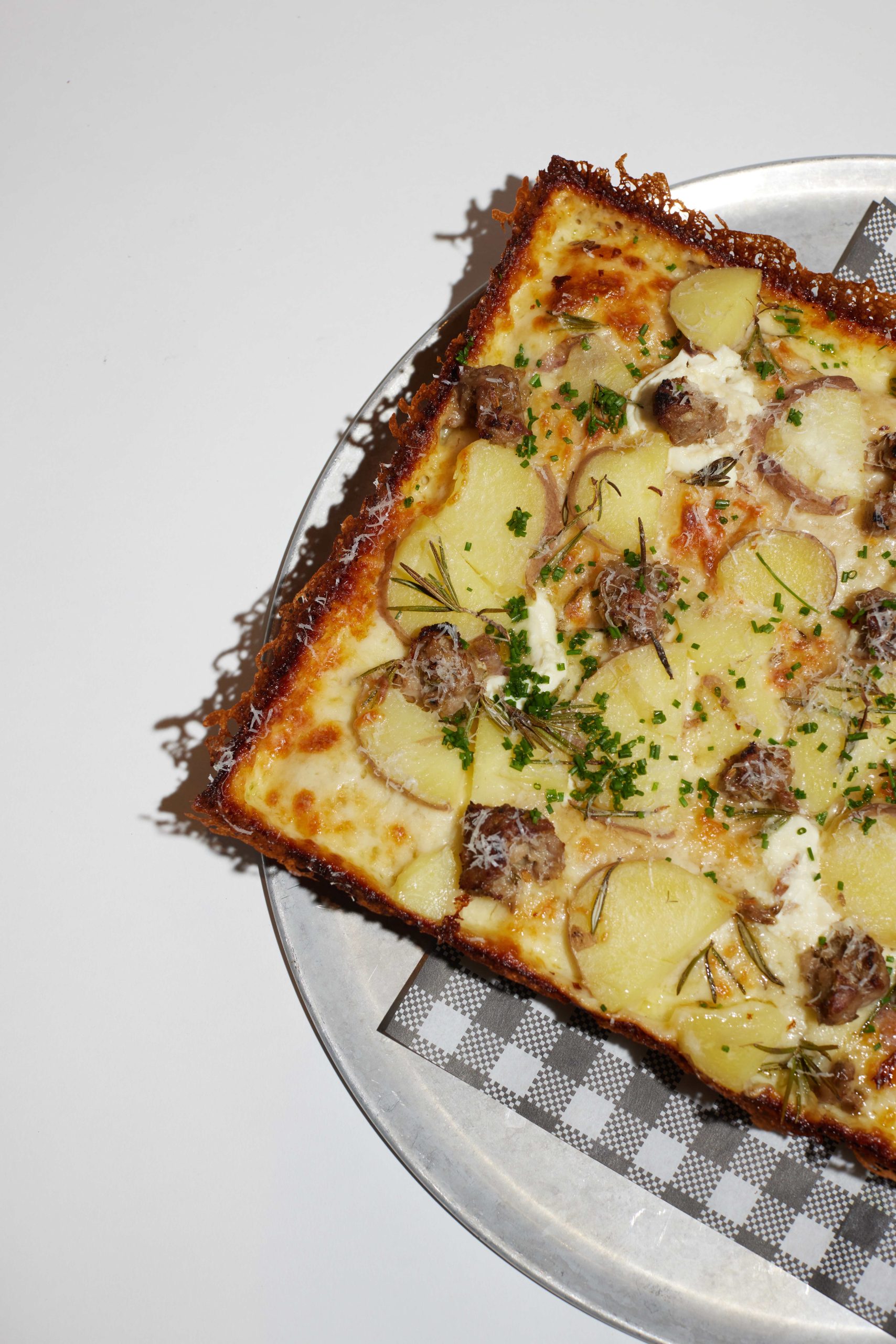 A slab of potato square pizza on a pizza board at City Oltra in Sydney