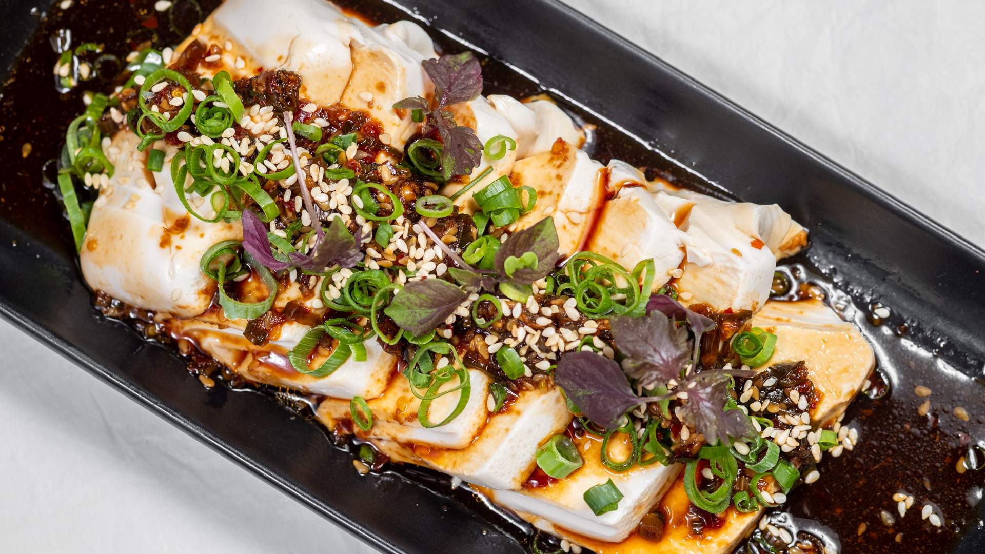 Silken tofu with chilli oil, sesame seeds, and herbs at China Diner in Sydney