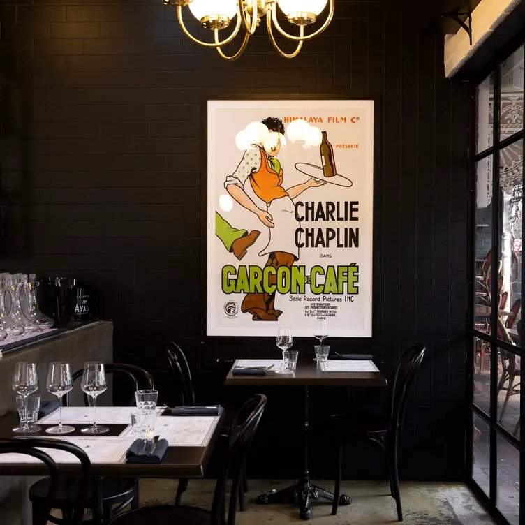 Black furniture and a large French poster at Bistro Français in Adelaide, one of the best restaurants in Australia