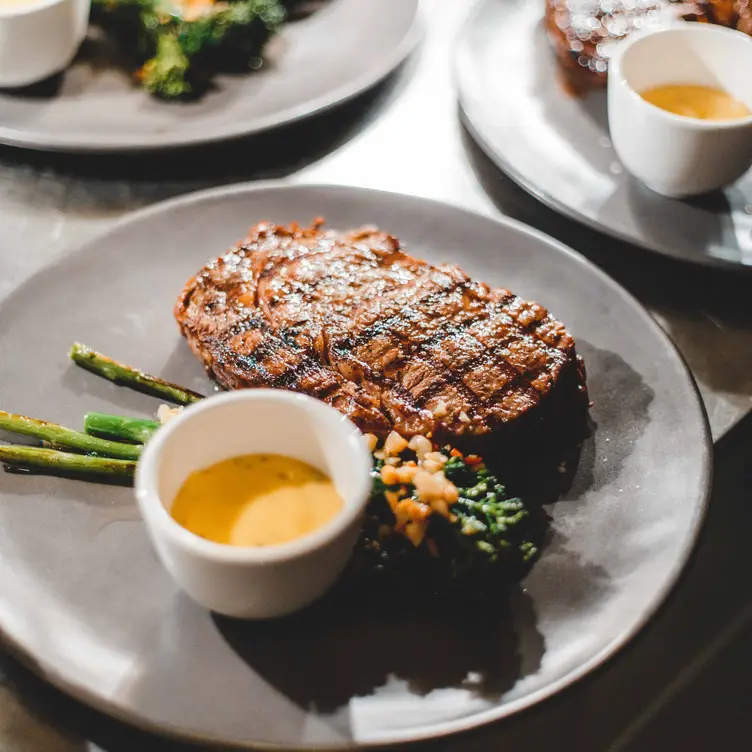 Char-grilled steak with broccolini and dipping sauce from Glass Brasserie - Hilton Sydney, one of the best steak restaurants in Sydney. Credit: Glass Brasserie – Hilton Sydney