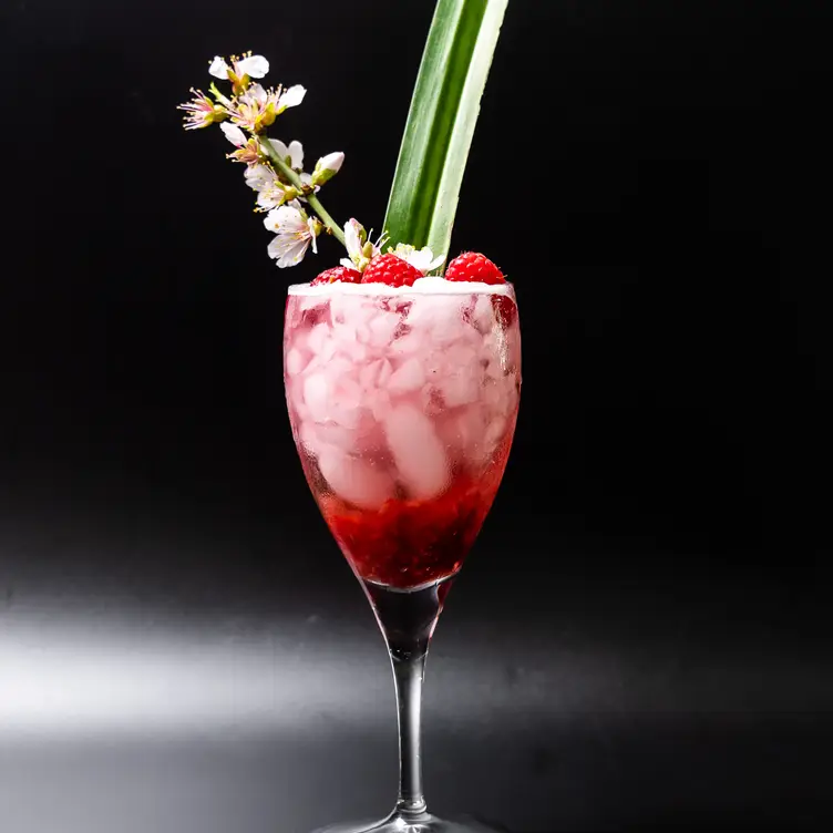 A bright red cocktail with a floral garnish at Cha Ching, one of the best Asian fusion restaurants in Melbourne