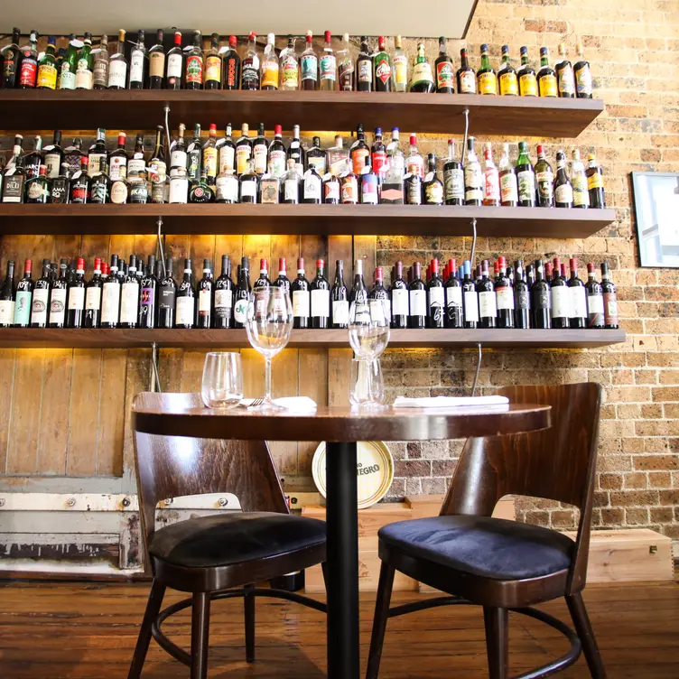 Well-stocked shelves of wine line the brick walls at Devine Food & Wine, one of the best steak restaurants in Sydney. Credit: Devine Food & Wine