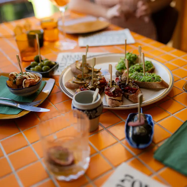 An array of vegan appetisers on a tiled table at Follies Bar – one of the best Melbourne vegetarian restaurants.