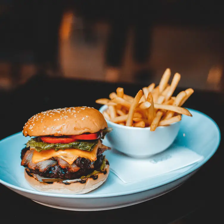 A burger and chips on a blue plate at Glass Brasserie - Hilton Sydney, one of the best steak restaurants in Sydney.. Credit: Glass Brasserie – Hilton Sydney