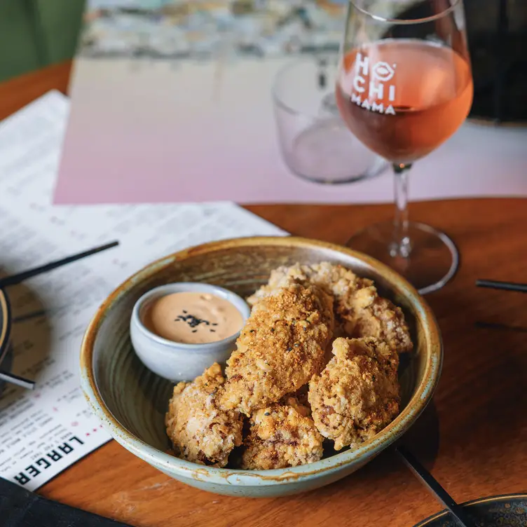 A dish accompanied by dipping sauce and a drink at Hochi Mama, one of the best Asian restaurants in Melbourne.