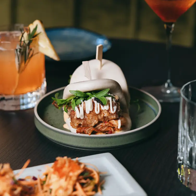 A plate with bao accompanied by a cocktail at Kiss and Tell, one of Melbourne’s best Asian restaurants.