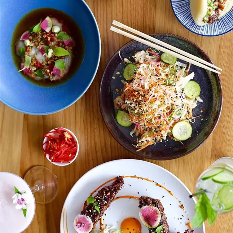 Several dishes and drinks on a table at Lucky Bao, one of the best vegan restaurants on the Gold Coast.