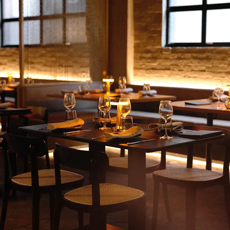 The modern dark brown tables and chairs, illuminated by warm lighting at Mr Vain, one of Brisbane’s best Asian restaurants.