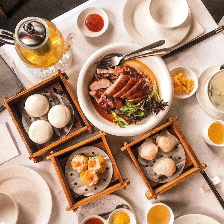 A table packed with plates and steam baskets at Secret Kitchen - Chinatown, one of the best Chinese restaurants in Melbourne.