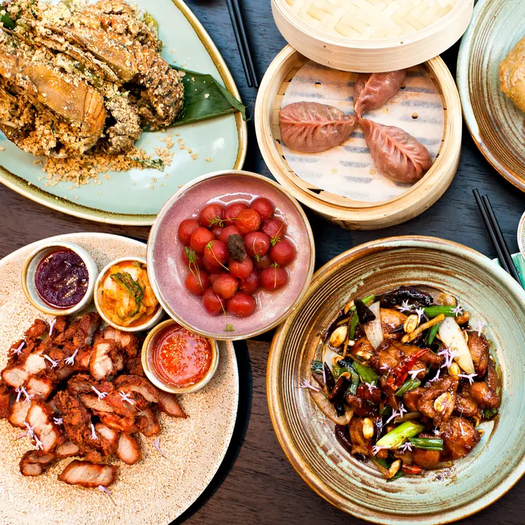 A table with multiple plates including seafood and salad dishes at Tai Tai, one of the best Chinese restaurants in Brisbane