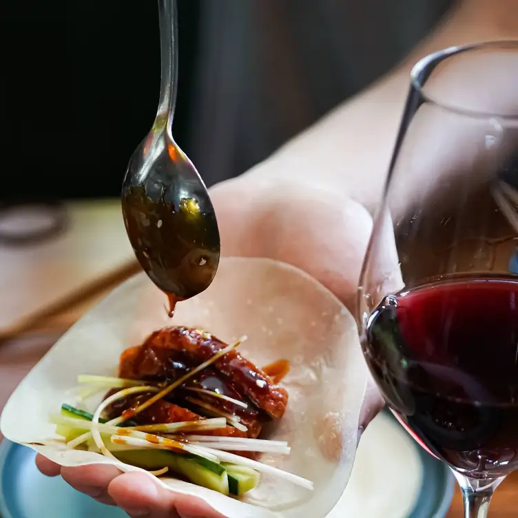 A guest at Uncle Wang, one of Brisbane’s best Asian restaurants, puts sauce on their dish.