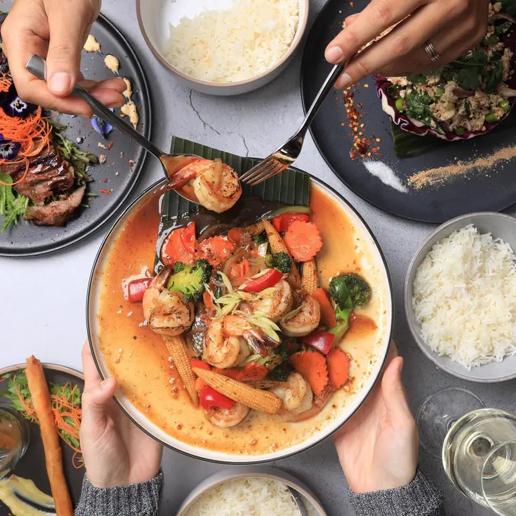 A diner takes a prawn from a dish served at The Baan Kurrajong.