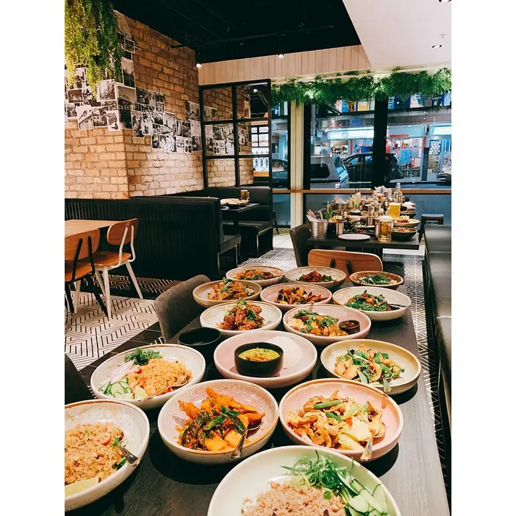 Several dishes and drinks line two tables at Khao Pla, one of Sydney’s best Thai restaurants.