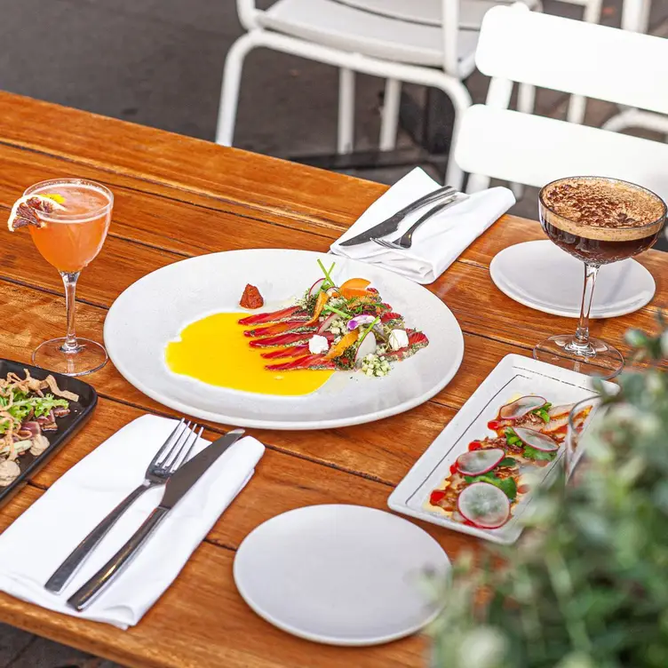 A table with various dishes and cocktails served at Waterfront Brighton.