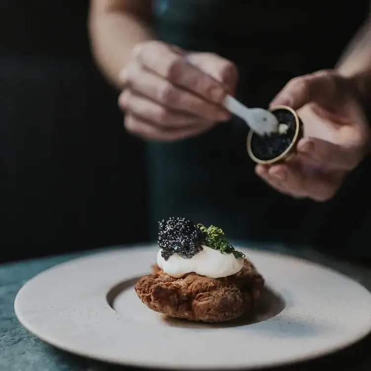 An entree being topped with caviar at Essa Restaurant.