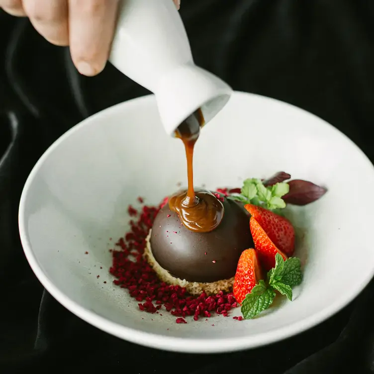 A dessert with chocolate and strawberries being plated at Deer Duck Bistro, one of the best casual date restaurants Brisbane couples adore.