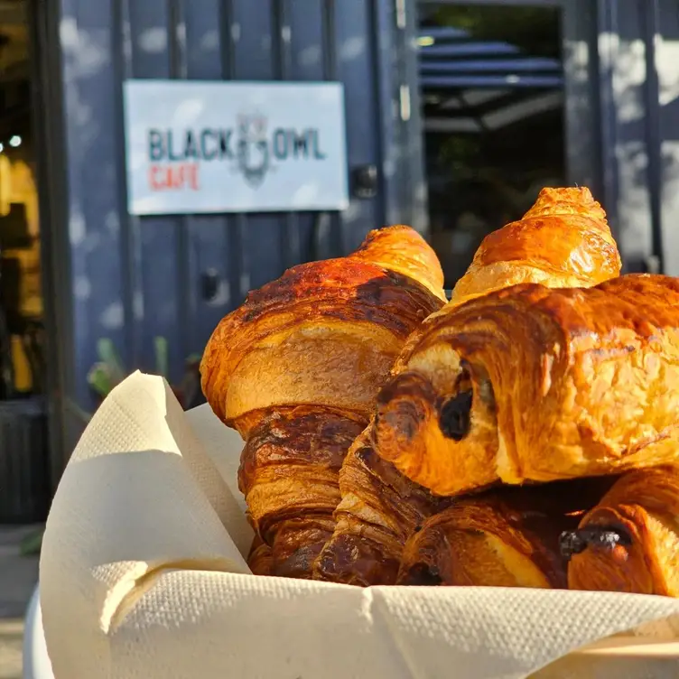 A basket of croissants on an outdoor table at Le Black Owl.