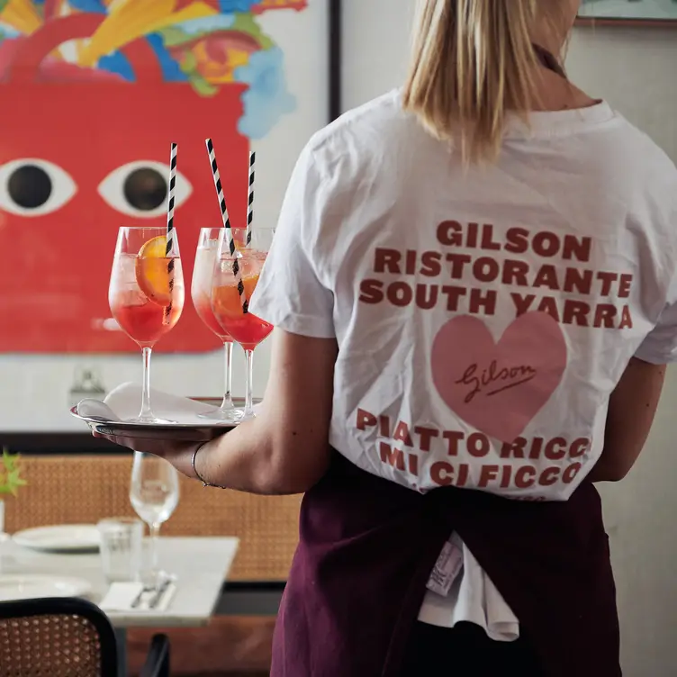 Waitstaff carrying a tray of cocktails at Gilson.