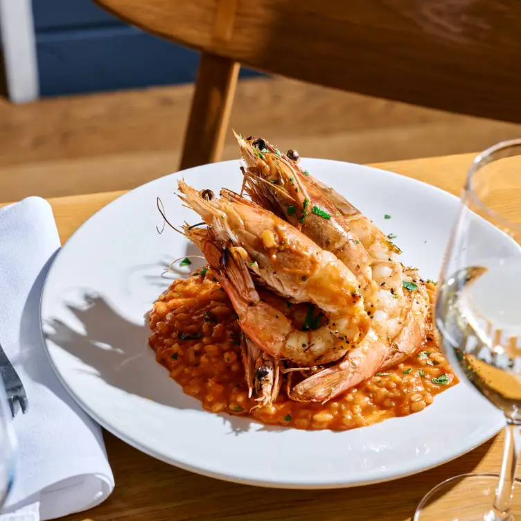 A plate of prawns and a glass of wine served at Pier Farm.