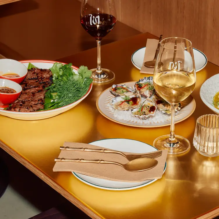 A few dishes served with glasses of red and white wine at Thai Tide - Melbourne CBD.