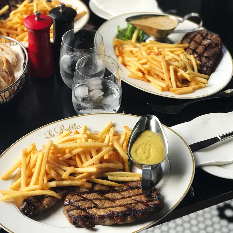 Plates of steak frites served at Les Bubbles Bar and Bistro, one of Brisbane’s best French restaurants.