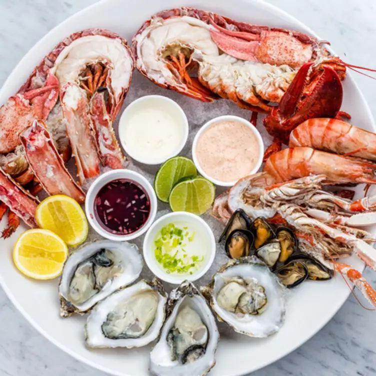 A large platter of fresh seafood with lemons, limes and dipping sauce at Acqualina, Sydney.