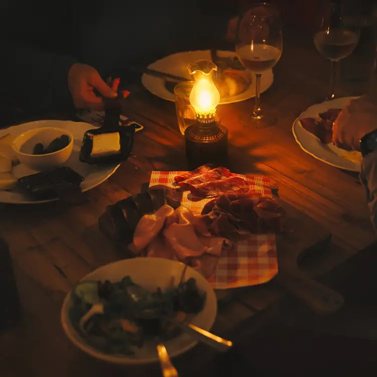 A table set with food and lit by a single lamp at Hemingway’s Manly.