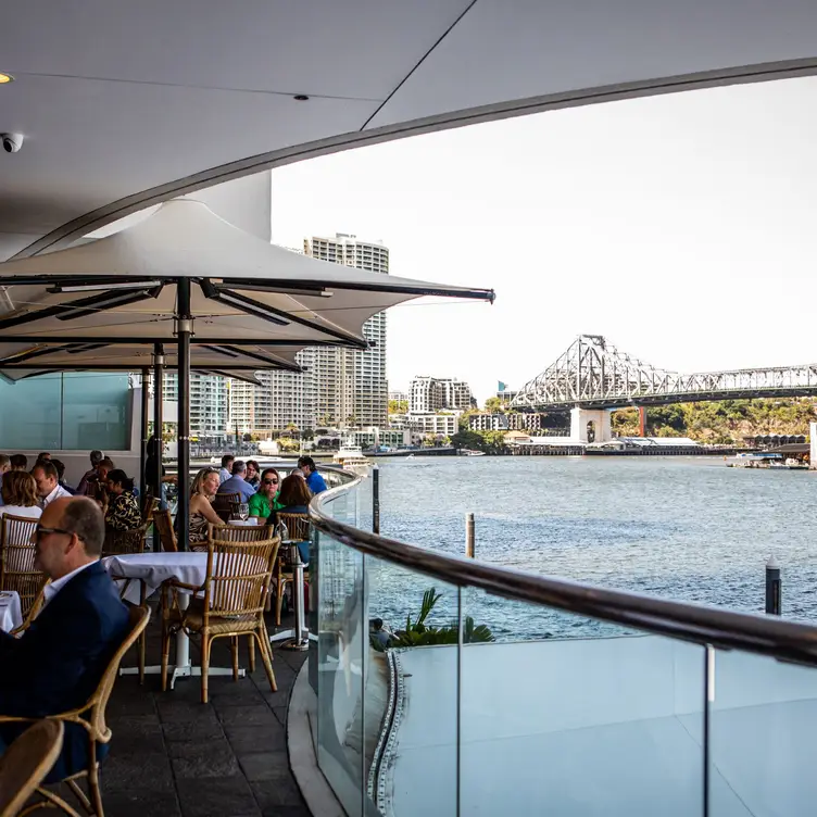 The outdoor dining area and view of the Brisbane River at Tillerman Seafood Restaurant.