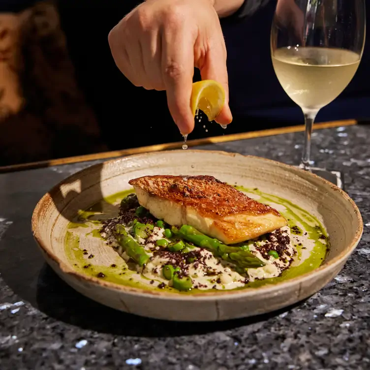 A salmon dish being garnished with lemon at Kazba, one of Brisbane’s best romantic restaurants.