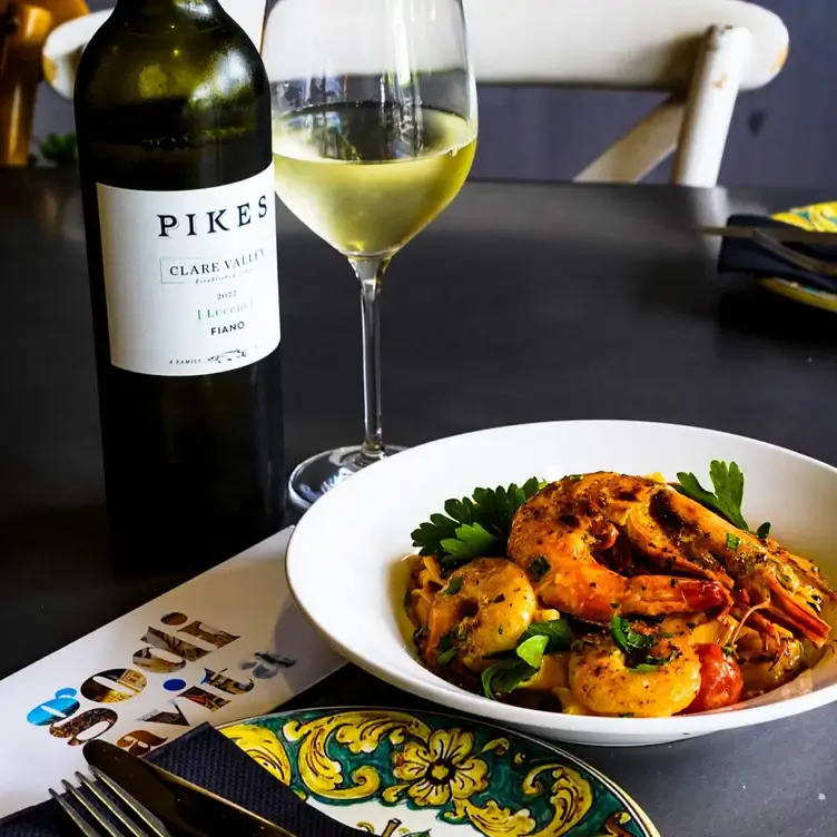 A seafood dish served alongside some white wine at Godi La Vita, one of the most romantic restaurants in Adelaide.