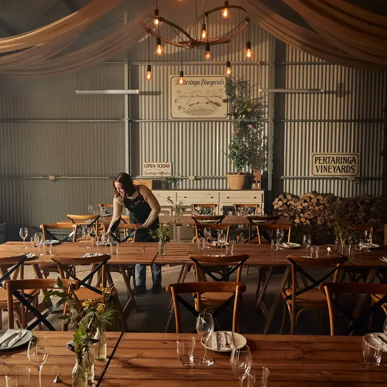 A waiter sets the long tables at Bec Hardy Wines’ interior dining space.