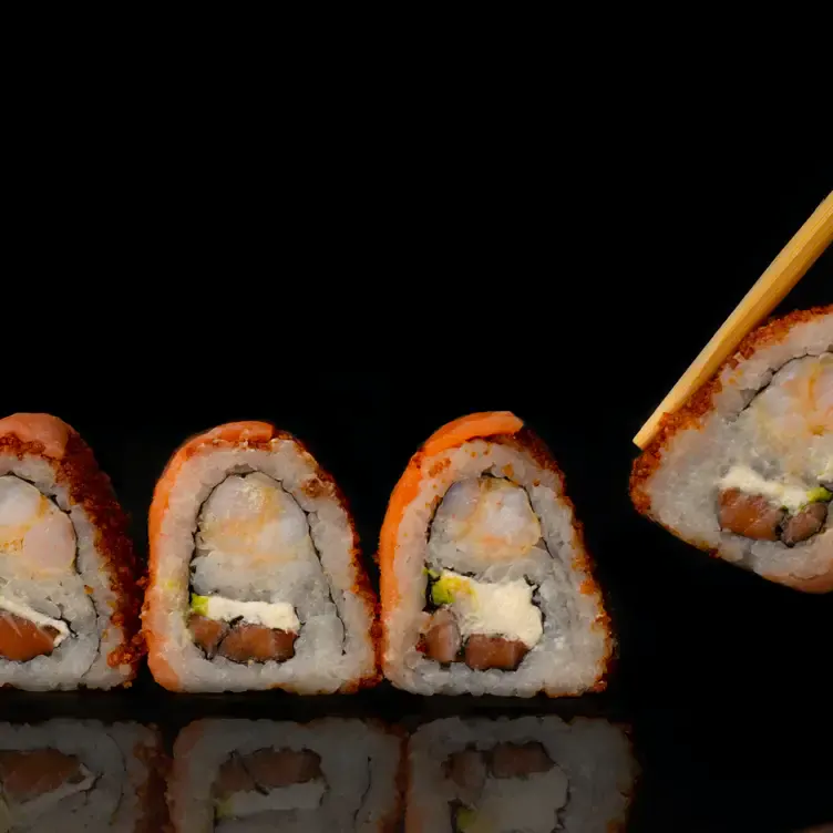 A diner removes one piece of sushi from a row of four slices at Shusai Mijo.