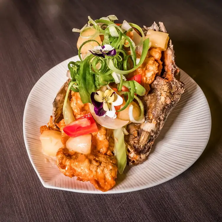 A fried dish topped with salad and flowers from District1 Modern Vietnamese Eatery, one of the best Asian restaurants in Adelaide.