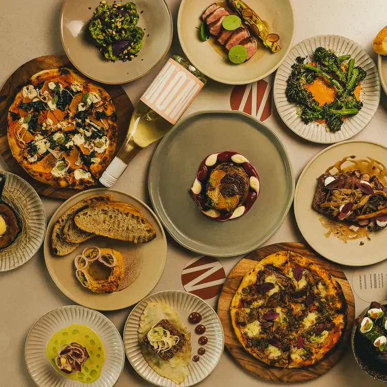 Multiple dishes including pizzas, steak and broccoli served at Wayward Winery, one of the best winery restaurants in Victoria.