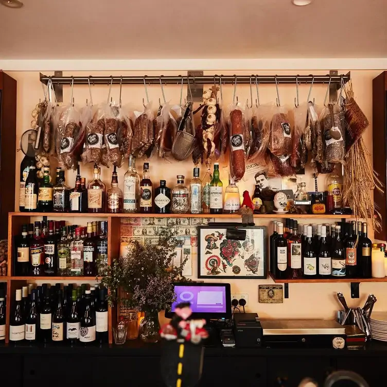 Shelves of various wines and spirits and a rack of salami, garlic and other foods at Chester White Cured Diner, one of the best new restaurants in Sydney in 2024.