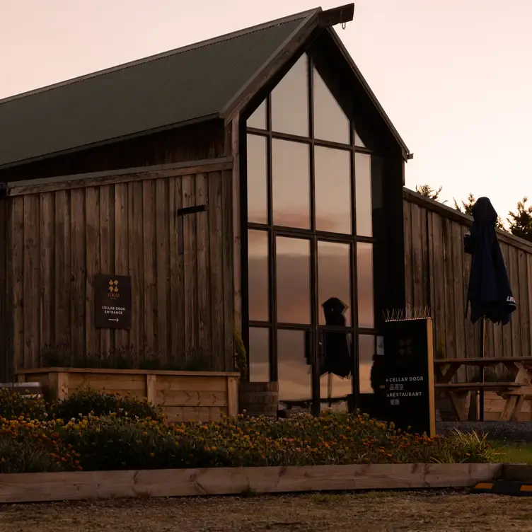 An exterior shot of Tokar Estate Cellar Door, showing a tall farmhouse with windows replacing one wall.