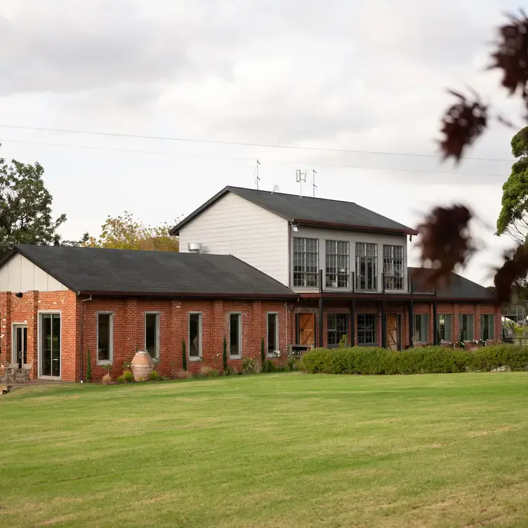 The exterior of Trofeo Estate’s red-bricked building and the lawn out the back.