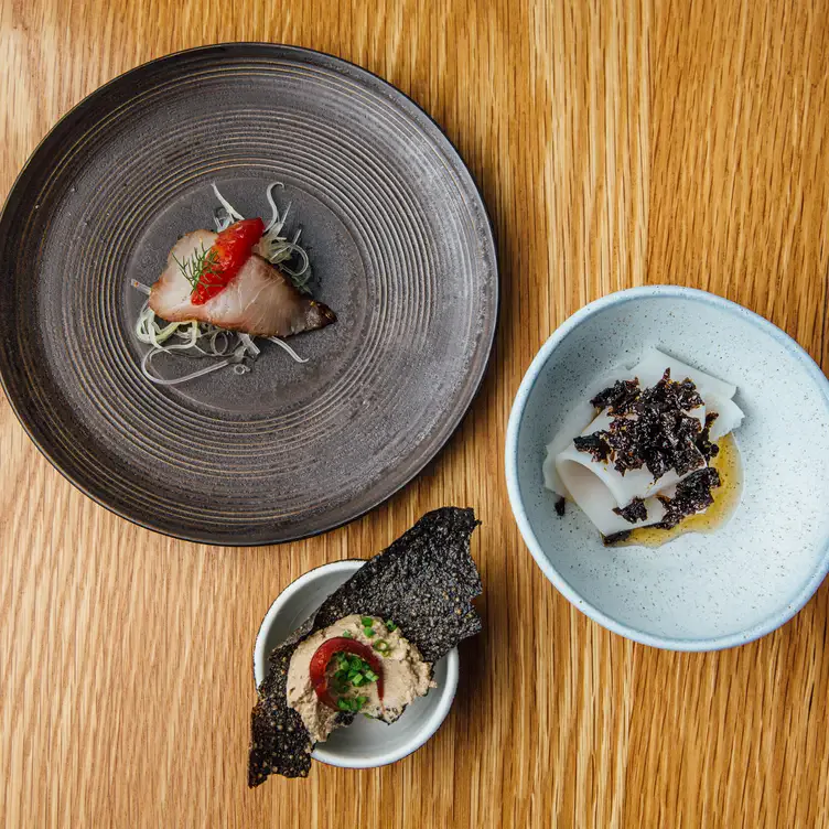 Three small dishes, each with just a few ingredients including fish, sauce and herbs served at Appellation, one of the best regional restaurants in South Australia.