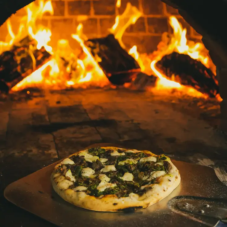 A freshly cooked pizza at the edge of a wood-fire oven at Wayward Winery, one of the best wineries in Victoria.