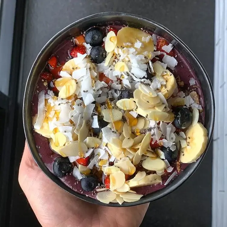 A fruit bowl with strawberries, blueberries, banana, coconut and almond shavings served at JIBBI & CO.