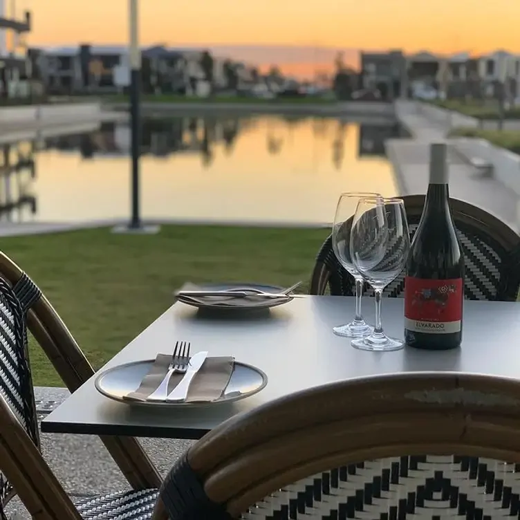 An outdoor table set for two with a bottle of wine at JIBBI & CO, one of the best regional restaurants in South Australia.