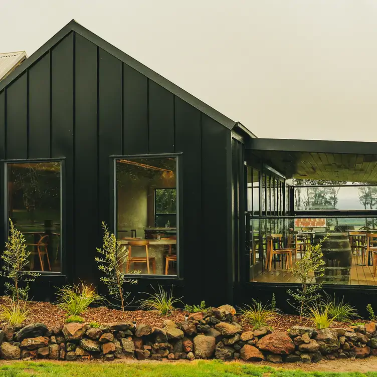 The exterior of Wayward Winery, showing the large windows that look into the indoor dining space and the sheltered verandah.