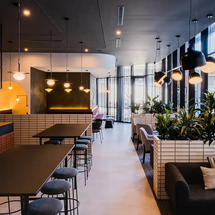 The interior dining space at No.10 Restaurant + Bar Belconnen, with tables separated by plants.