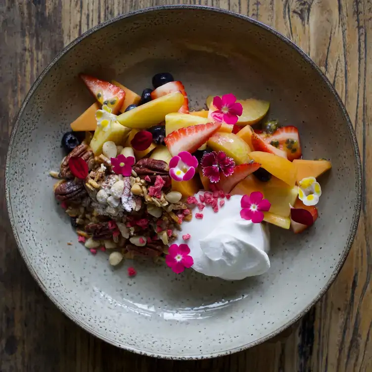 A bowl of granola with nuts, strawberries and blueberries served at Wild Canary, one of the best family restaurants in Brisbane.